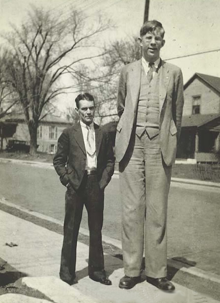 Vemos aun hombre demasiado alto y otro hombre a su lado de una estatura normal
