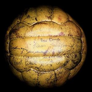 Vemos otro balon modelo antiguo de color amarillento con firmas de todo los jugadores del equipo