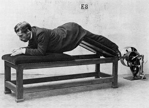Vemos un hombre haciendo ejercicios  sobre una camilla especial de ejerciciosgimnasticos de la epoca 