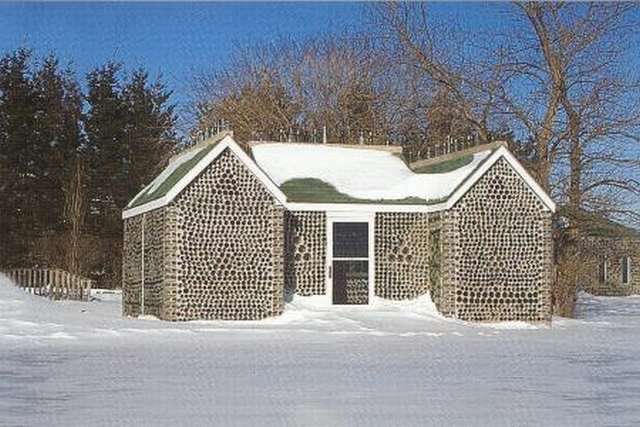Ahora vemos otro casa  con todas sus paredes con botellas sus techos estan cubiertos de nieve y su piso tambien