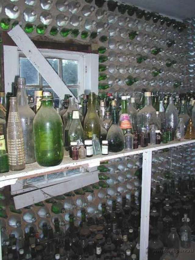 Vemos una  casa con muchas botellas de diferentes colores y en unacornisa de la ventana se ven muchas botellas de diferntes colores y estilos