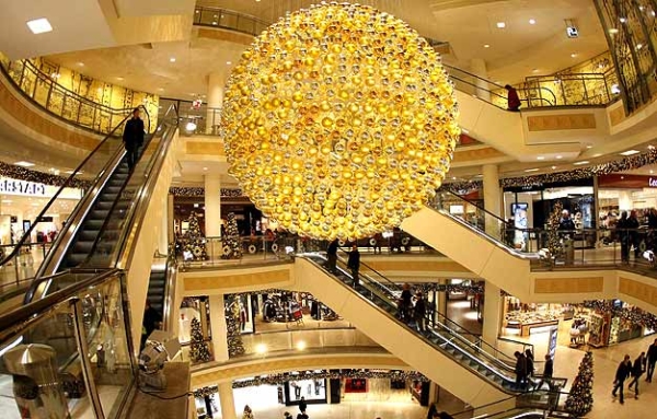 Vemos un grande centro comercial con un gran globo iluminado con sus luces doradas que dan un lindo tono de luces