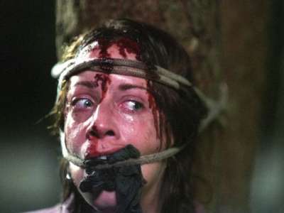 Vemos a una persona que lleva un trapo amarrado a su boca  y en su frente tambien tiene algo que lo ata