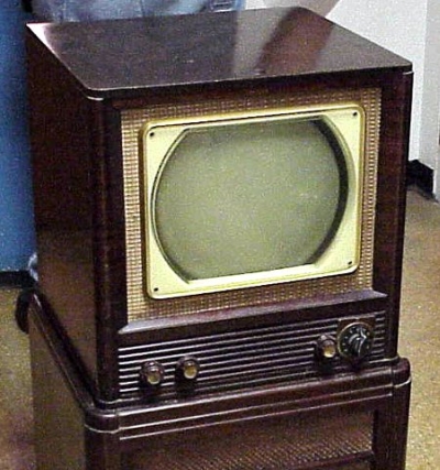 Vemos un antiguo televisor dentro de una especie de cajon en madera