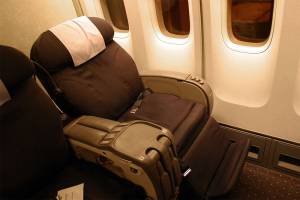Vemos una silla de avión color café  mojada con orina y su cinturón igual 