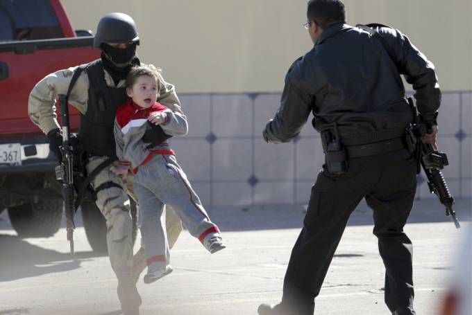  vemos a un niño cargado por un militar que lo saca de un lugar  peligroso