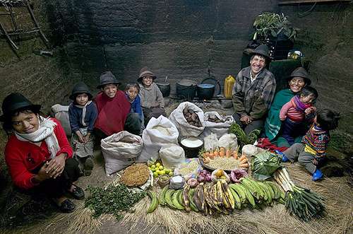 Una familia indigena que come yucas papas plátanos cebollas arroz y frijoles