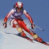 vemos a una mujer en una carrera  de ski sobre la nieve bajando