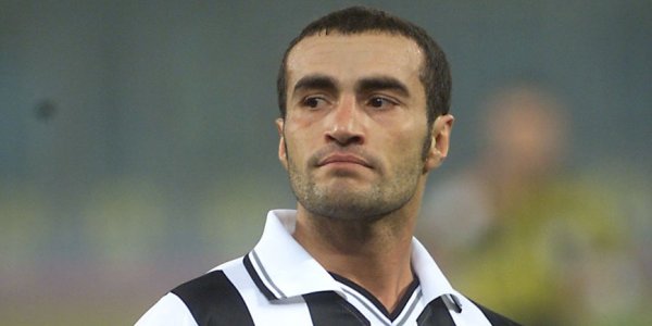 Un jugador de pelo oscuro y corto mira perdidamente en la cancha