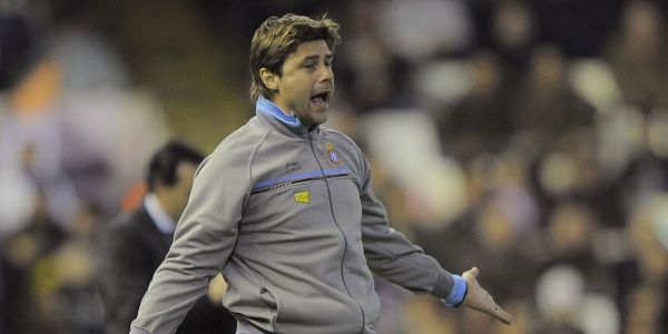 Vemos un jugador con chaqueta deportiva gris que grita en mitad de cancha