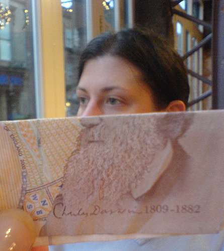 Una mujer la mitad de su rostro se completa  con la mitad de la foto de un billete que es un hombre