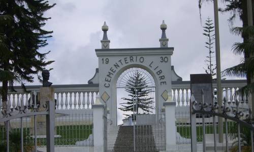 Tenemos la entrada ca aun cementerio todo en blanco y se ven muchos pinos verdes