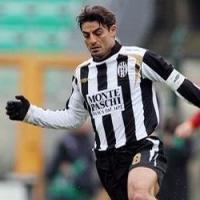 Un futbolista  con chaqueta de color verde y manos enguantadas lleva la pelota hacer una superjugada 