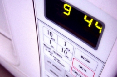Vemos un horno microondas  en color blanco con sus botones de prendido  apagado y  su numeración digital