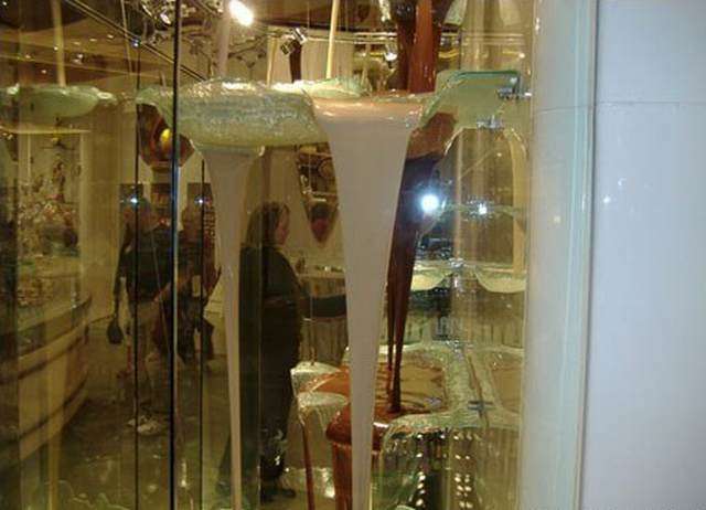 Vemos el chocolate blanco y café pasando por  caídas y cayendo en recipientes de vidrio