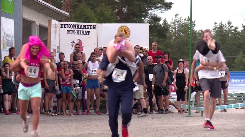 Tres hombres corriendo con sus esposas al hombro