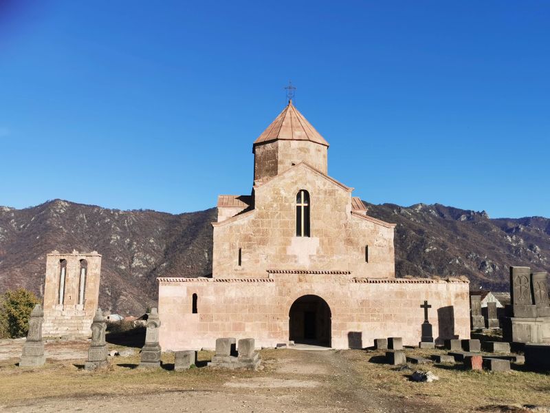 Iglesia cúbica con un camino de arena y un cementerio