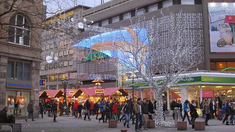 Vemos unos grandes construciones algo antiguas y muchas personas que pasan
