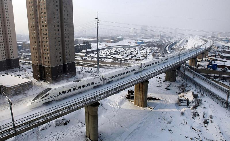 Vemos un tren que avanza en su carrilera una ciudad con muchos edifios y rscacielos es algo ytamquila y rscacielos
