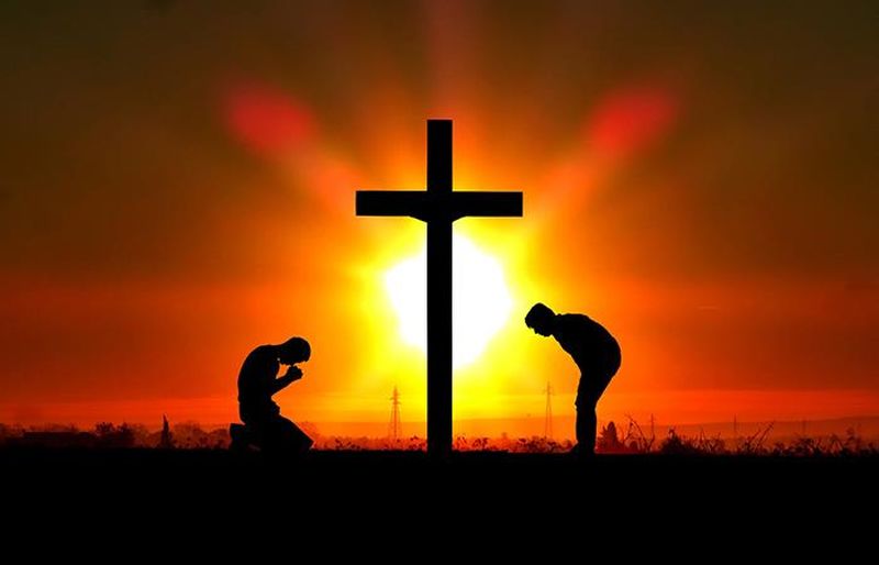 Personas al lado de una cruz