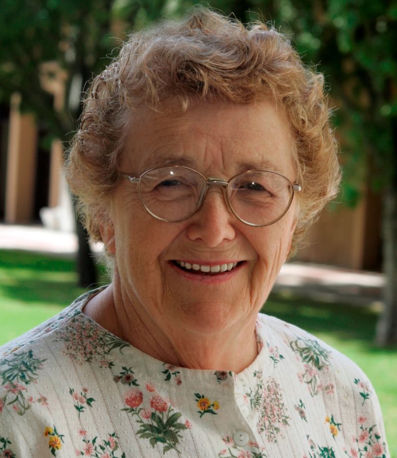 Mujer de la tercera edad con lentes y sonriente
