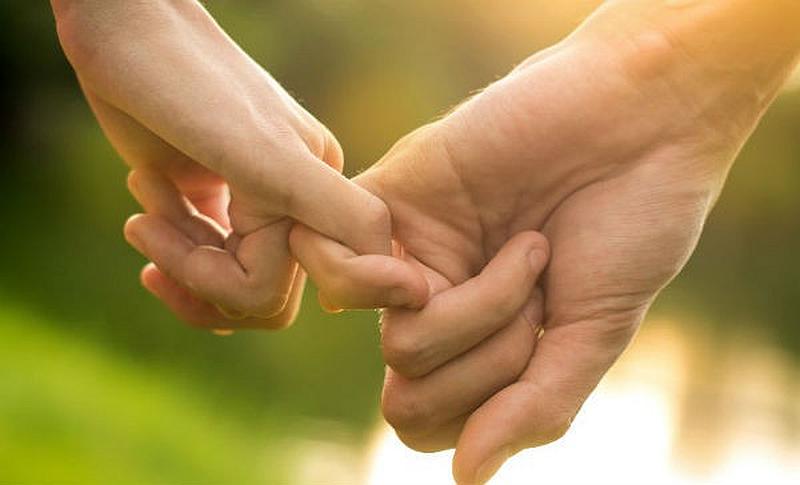 Vemos dos manos con dedos entrelazados