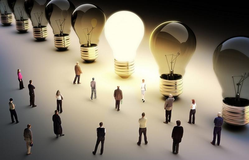 Vemos muchas personas en un recinto muy grande y unos inmensos bombillos de varias tonalidades