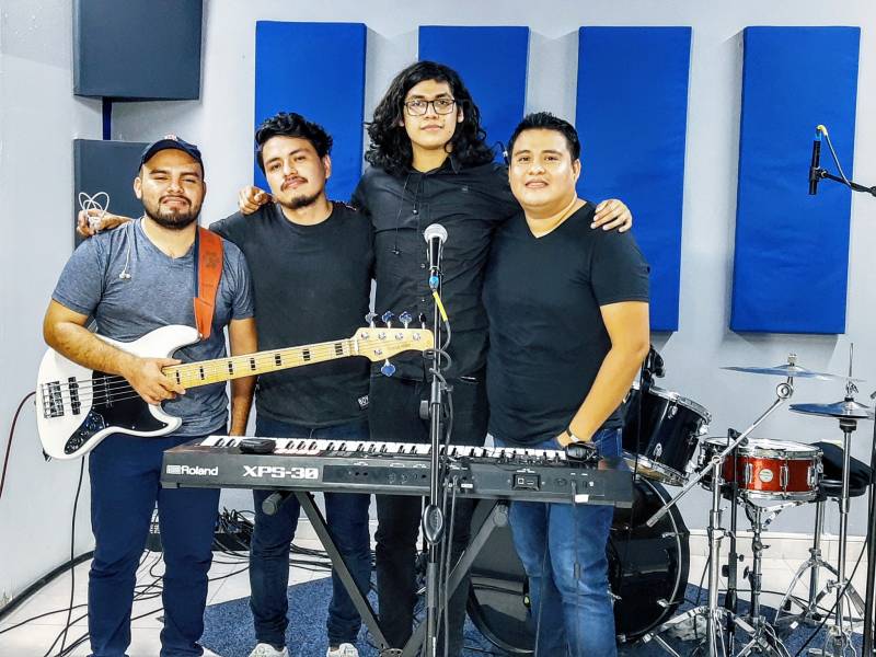 Grupo conformado por cuatro hombres de diferentres composturas donde los rodean varios intrumentos musicales
