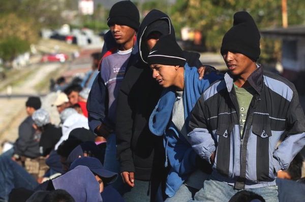 varios hombres muy jóvenes esperan  algo para continuar la marcha