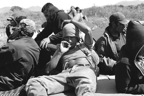 Vemos unas personas sentadas que fuman y aguardan algo