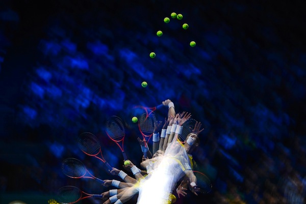 Vemos una mano con una raqueta de tennis  de la que se ven muchas mas manos y raquetas por la forma en que fue tomada
