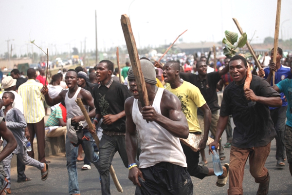  hombres de color armados con palos avanzan en una protesta