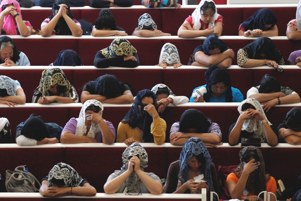 Vemos muchas mujeres con mantos de encaje en sus cabezas que se agachan a orar todas están  orando por algo en comun