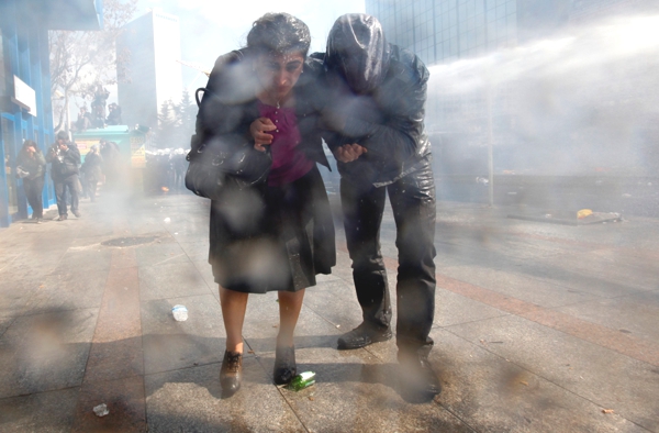Vemos a una pareja  que avanza en medio de mucho humo  tratan de avanzar por que el humo impide ver bien para caminarom 