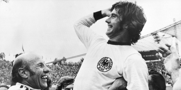 Vemos un futbolista que celebra con otras personas un triunfo