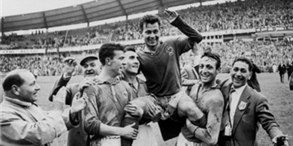 Vemos aun futbolista cargado  por sus compañeros de equipo cuando celebran un triunfo