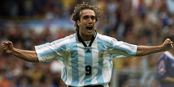 Vemos aun jugador con uniforme azul de rayas blancas que corre dando un  grito de  triunfo
