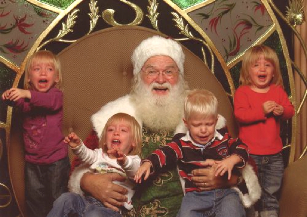 Vemos a Santa Claus Con cuatro hermoso niños que lloran y no disfrutan de su precencia