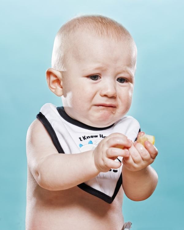 Otro pequeño bebe no le gusta el limón y hace un  gesto con su boca