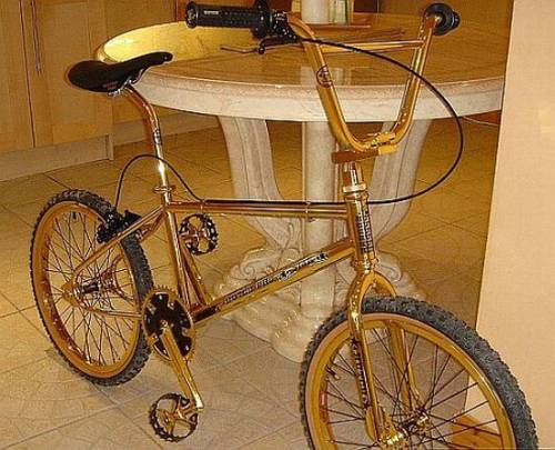 Vemos una bicicleta  dorada  con sillín negro  manubrios y radios todo en dorado